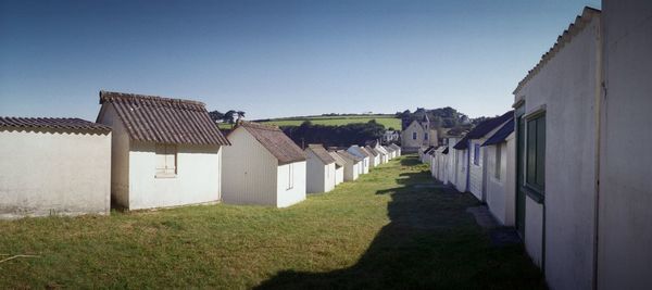 Houses amidst buildings against clear sky