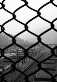 High angle view of cityscape seen through chainlink fence