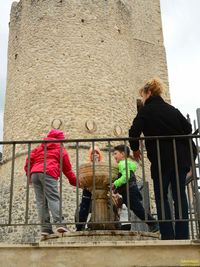 Low angle view of children playing by fountain at historic building