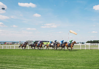 People running on field against sky