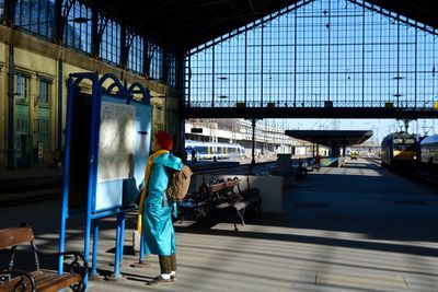 Side view of woman reading map at railroad station