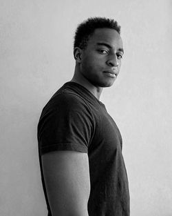 Portrait of young man looking away against white background