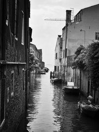 Boats in canal with buildings in background