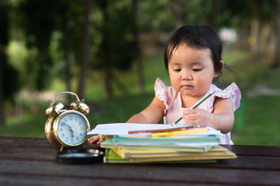 Close-up of girl studying at park