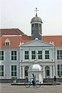 People in front of building against clear sky