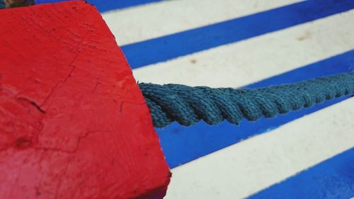 Close-up of blue rope attached to red stone