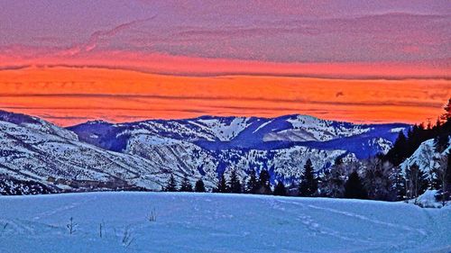 Scenic view of snowcapped mountains during sunset