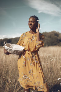 Woman standing on field against sky