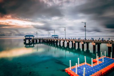 Pier on sea against sky during sunset