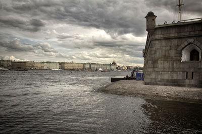 Buildings by sea against sky