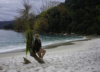 Portrait of young woman relaxing on beach