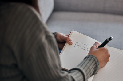 Midsection of man reading book