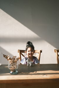 Portrait of boy sitting on table