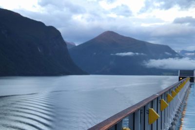 Scenic view of lake by mountains against sky