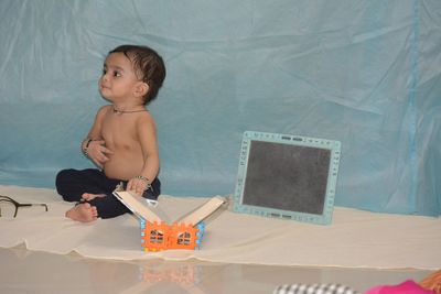 Cute boy with toy against wall