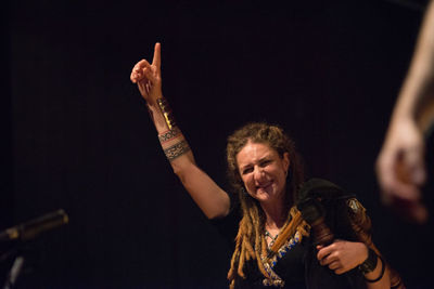 Man with arms raised in background