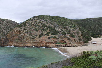 Scenic view of sea and mountains against sky