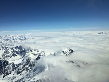 Scenic view of snowcapped mountains against blue sky