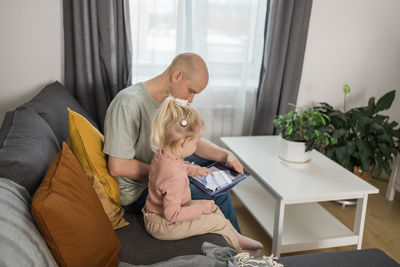 Side view of mother and daughter at home