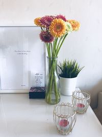 Flower vase on table against wall