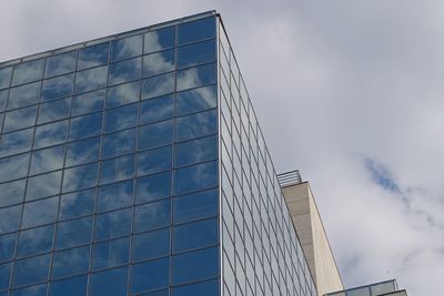 Low angle view of modern building against cloudy sky