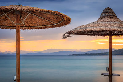 Traditional windmill on beach against sky