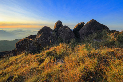Rock formations on landscape against sky during sunset