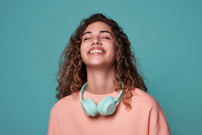 Portrait of smiling woman against blue background