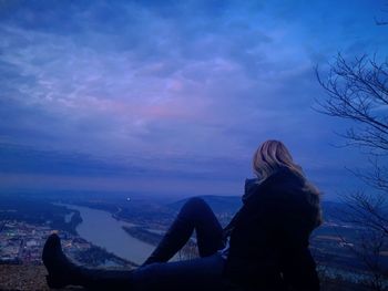 Rear view of woman sitting against sky