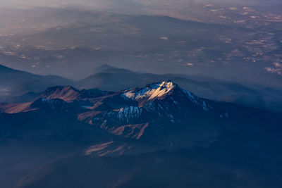 Aerial view of snowcapped mountain against sky