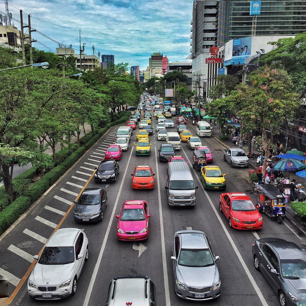 transportation, car, land vehicle, mode of transport, city, building exterior, street, architecture, traffic, built structure, road, city life, high angle view, city street, on the move, tree, incidental people, diminishing perspective, sky, the way forward