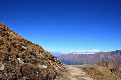 Scenic view of arid landscape against clear blue sky