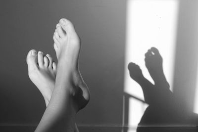 Low section of woman against shadow on wall