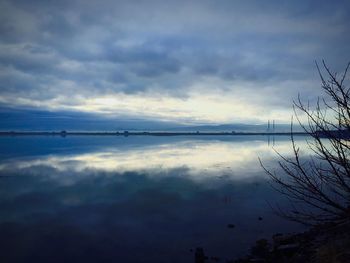 Scenic view of calm lake against cloudy sky