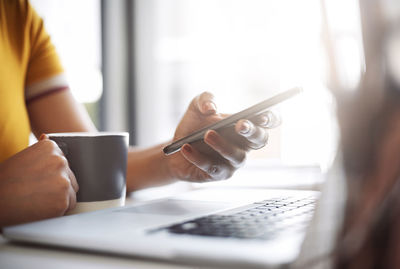 Midsection of woman using mobile phone