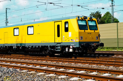 Yellow train on railroad track against sky