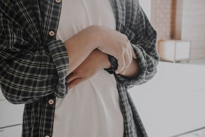 Midsection of woman standing at home