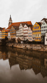 Reflection of houses in river against sky