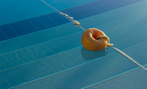 High angle view of rope tied to buoy on swimming pool