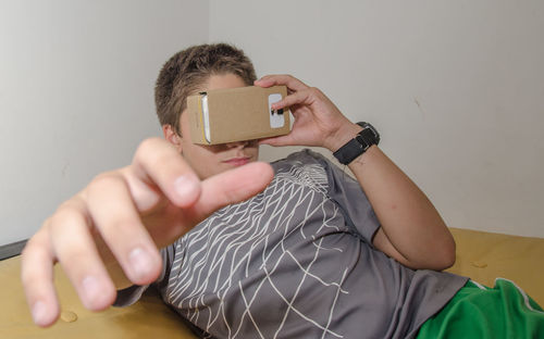 Close-up of boy gesturing while wearing virtual reality simulator