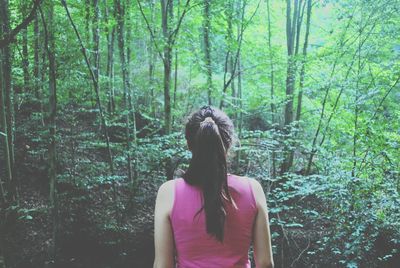 Rear view of woman standing in forest