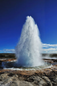 View of geyser against blue sky