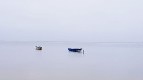 Boat moored in lake against clear sky