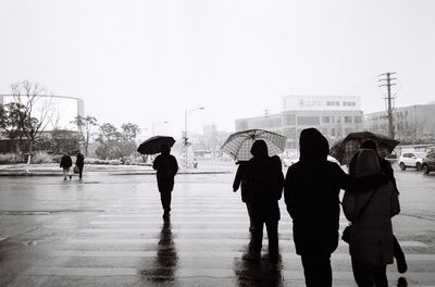 People standing on wet road during rainy season