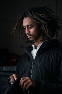Young woman looking away while sitting at home