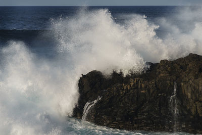 Waves splashing in sea against sky