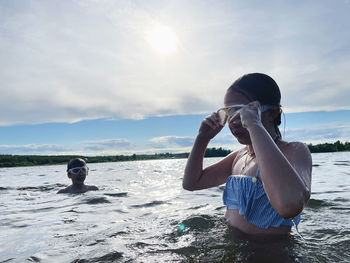 Rear view of woman photographing sea against sky