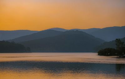 Scenic view of lake against orange sky