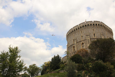 Low angle view of the windsor castle against sky and a plane next to it