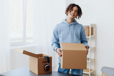 Portrait of young woman holding box